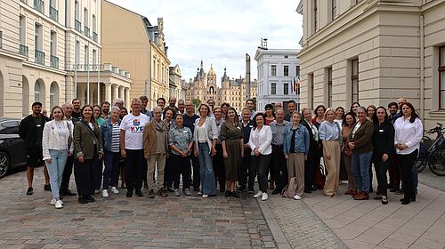 Austausch zur Zusammenarbeit mit der Ukraine Eine größere Gruppe steht für ein gemeinsames Foto in der Schweriner Innenstadt.
