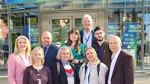 Projektpartner von DigiTechPort2030 bei der TOC Europe 2026 in Hamburg Mehrere Projektpartner des DigiTechPort2030-Konsortiums stehen vor dem Eingang der TOC Europe 2026 in Hamburg. Über ihnen befindet sich ein großes Willkommensschild der Fachmesse.